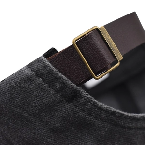 Detail of adjustable leather strap and bronze metal buckle on gray vintage baseball cap