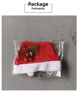 Detail of red plush Christmas hat with gold ornaments in clear plastic packaging