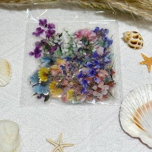 Close-up of waterproof ink-wash flower stickers on textured fabric with seashells