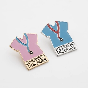 Detailed view of medical scrubs enamel pins with Superhero in Scrubs text and stethoscopes