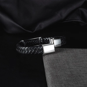 Dettaglio del bracciale in pelle intrecciata da uomo con chiusura in acciaio al titanio