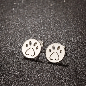 Detail shot of silver cat paw stud earrings with heart-shaped hollow-out design