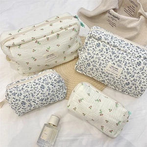 Macro detail of quilted cotton makeup bags with floral patterns and soft fabric texture