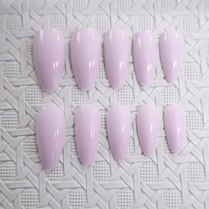 Glossy light purple almond-shaped press-on nails set displayed on a white textured background