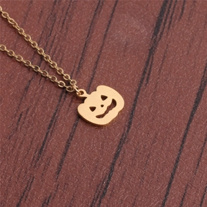 Polished gold stainless steel pumpkin lantern necklace on dark wood background
