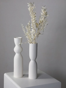 Detail shot of white ceramic vases featuring horizontal ribbed texture and matte finish