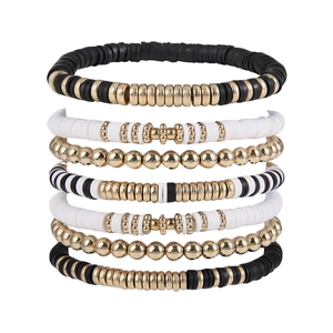 Detail of 7-piece bohemian stackable bracelet set with black and gold heishi beads