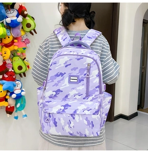 Rear view of a student wearing a purple camo backpack with a fashion rubber label