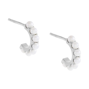 Detailed macro view of S925 sterling silver C-shaped earrings with inlaid white pearls