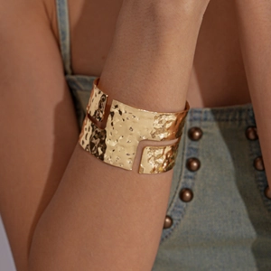 Irregular textured gold bangle with a geometric open design and hammer effect