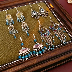 Flat lay of vintage style tassel earrings with zircon floral and pearl accents