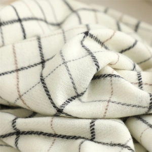 Close-up of soft plaid scarf fabric showing beige and brown woven texture and pattern