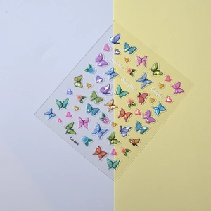 Detailed close-up of colorful butterfly and heart nail art stickers on a clean dual-tone background