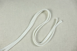 Macro shot of off-white ribbed knit ties featuring a high-density woven texture detail