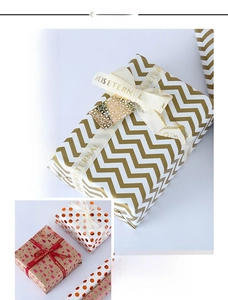 Close-up of gold wave gift wrap with silk ribbon printed with LOVE IS ETERNAL text