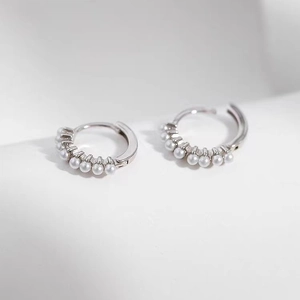 Boucles d'oreilles huggie en argent avec petites perles blanches pour un style élégant