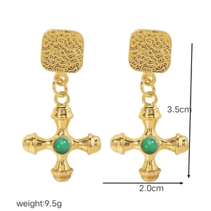 Detail view of gold cross earrings with green stone inlay showing size dimensions