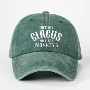 Detailed view of white circus monkey slogan print on washed green cotton baseball cap