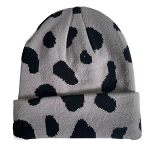 Detailed view of gray knitted beanie featuring black spotted texture and soft warm fabric