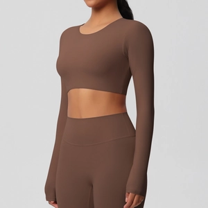 Détail du haut de yoga marron avec poignets passe-pouce et tissu mat très élastique