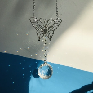 Close-up of metal butterfly suncatcher with crystal beads and rainbow reflecting ball