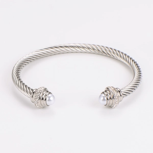 Detail of twisted cable steel bangle featuring inset pearls and sparkling crystal bands