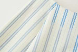 Close-up of the breathable blue and white striped cotton fabric texture on the casual outfit