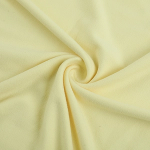 Vue macro détaillée d'un tissu en coton tricoté jaune pâle doux avec plis élégants