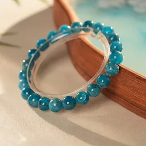 Elegant beaded bracelet with polished blue-green apatite crystal beads on a clear stand