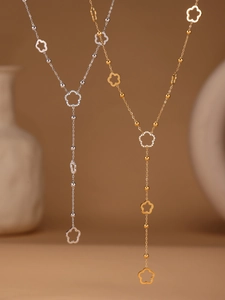 Close-up of gold and silver Y-shaped necklaces with hollow flowers and zircon inlay