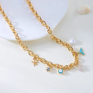 Detail of nautical charms with starfish, turtle, and shell on golden chain necklace