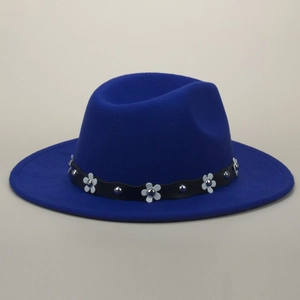 Close-up of a blue wool fedora featuring white floral rivets and silver studs on a black belt