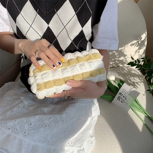 Detail of yellow and white checkered bubble fabric pouch with 3D pleated texture