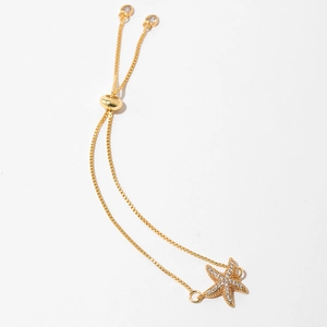 Detailed close-up of a gold-plated starfish bracelet with sparkling zircon stones and bolo clasp