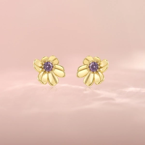 Detail of gold floral stud earrings featuring centered round purple zircon stones