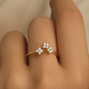 Macro view of gold flower ring with crystal stones on a model's finger