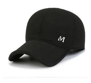 Detailweergave van de winterpet met zilveren metalen M-logo en warme wollen textuur