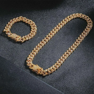 Detailed view of iced-out gold Cuban link necklace and bracelet set with rhinestones