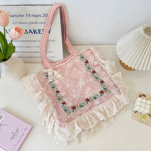 Close-up of pink plaid tote bag featuring intricate floral embroidery and lace borders