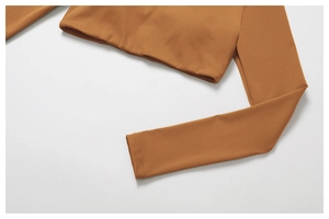 Détail du haut de yoga caramel montrant la texture du tissu lisse et les coutures de finition