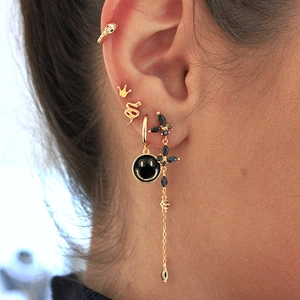 Detailed view of gold-tone earring set featuring snake studs and butterfly tassel pendant