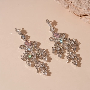 Dettaglio di lussuosi orecchini a cuore con strass rosa e frange in argento