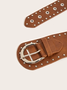 Detail of vintage brown leather belt with silver studs, eyelets and horseshoe buckle
