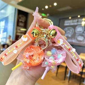 Dettaglio di portachiavi a lecca-lecca con glitter liquidi e cinturini con unicorno