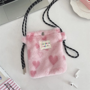 Detail of pink plush heart crossbody bag showing fuzzy texture and metallic snap closure
