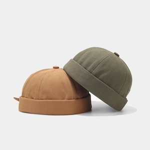 Détail de bonnets miki en toile caramel et vert olive avec bords roulés et texture