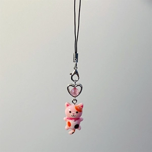 Close-up of a pink Y2K cat phone charm with heart metal frame and colorful beads