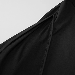 Detail of high-density black knit fabric with precise stitching on a side slit dress