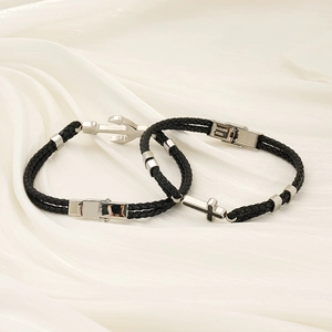 Détail de bracelets en corde tressée avec pendentifs ancre et croix en acier inoxydable