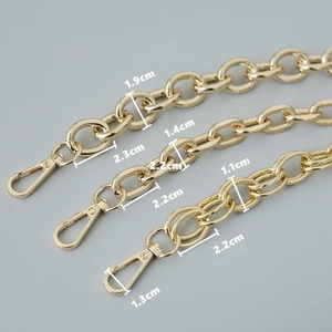 Detailed view of gold metal purse chains with varied link styles and lobster clasps